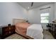 Inviting bedroom with wood-look floors, a comfortable bed, and natural light at 3952 Aldea Way, Wesley Chapel, FL 33543