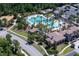 Aerial view of a community pool with slides, lounge chairs, and umbrellas at 3952 Aldea Way, Wesley Chapel, FL 33543