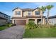 Charming two-story home featuring a stone facade, covered porch and well-manicured landscaping at 3952 Aldea Way, Wesley Chapel, FL 33543