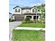 Charming two-story home featuring a stone facade, covered porch and well-manicured landscaping at 3952 Aldea Way, Wesley Chapel, FL 33543