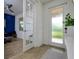 Inviting foyer featuring wood-look tile floors leading to a cozy office space with blue accent wall at 3952 Aldea Way, Wesley Chapel, FL 33543