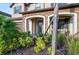 Inviting front porch with stone accents, comfortable seating, and lush landscaping at 3952 Aldea Way, Wesley Chapel, FL 33543