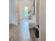 Bright hallway with wood-look tile flooring, arched entryway, and elegant wainscoting details at 3952 Aldea Way, Wesley Chapel, FL 33543