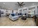 Spacious living room open to kitchen with large sectional and wood-look floors at 3952 Aldea Way, Wesley Chapel, FL 33543
