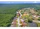 An overhead view shows a home nestled in a serene neighborhood close to natural beauty and a large pond at 4012 Wellington Pkwy, Palm Harbor, FL 34685