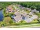 A picturesque aerial view showcases a home with a screened-in pool, lush greenery, and neighborhood charm at 4012 Wellington Pkwy, Palm Harbor, FL 34685