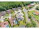 An aerial view captures a home nestled in a community with mature trees and a nearby pond at 4012 Wellington Pkwy, Palm Harbor, FL 34685
