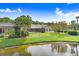 Expansive backyard featuring a screened-in pool area and scenic pond view with mature trees at 4012 Wellington Pkwy, Palm Harbor, FL 34685