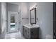 Bright bathroom with marble floors, glass shower, and modern vanity with framed mirror at 4012 Wellington Pkwy, Palm Harbor, FL 34685