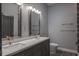 Modern bathroom featuring double sinks, stylish mirrors, and tiled shower at 4012 Wellington Pkwy, Palm Harbor, FL 34685
