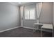 Well-lit room showcasing a window with white shutters and matching curtains, and a white, modern L-shaped desk at 4012 Wellington Pkwy, Palm Harbor, FL 34685
