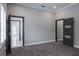 Spacious bedroom featuring neutral walls, gray carpet, and modern dark-stained doors at 4012 Wellington Pkwy, Palm Harbor, FL 34685