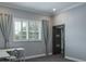 Well-lit bedroom featuring a window with white shutters and elegant curtains, and a door leading to bathroom at 4012 Wellington Pkwy, Palm Harbor, FL 34685