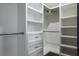 Organized walk-in closet with white shelving and drawers and metal hanging rods for optimal storage at 4012 Wellington Pkwy, Palm Harbor, FL 34685