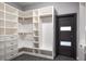 Custom walk-in closet featuring multiple shelving units and drawers, as well as a sleek modern door at 4012 Wellington Pkwy, Palm Harbor, FL 34685