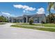 Charming single-story home with manicured lawn, complementing the gray exterior and stone paver driveway at 4012 Wellington Pkwy, Palm Harbor, FL 34685
