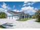 Spacious three-car garage with a stone paver driveway enhancing the curb appeal at 4012 Wellington Pkwy, Palm Harbor, FL 34685