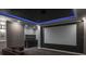 Home theater with a large screen, custom cabinetry, and ambient lighting for immersive viewing experiences at 4012 Wellington Pkwy, Palm Harbor, FL 34685