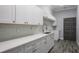 Kitchen with white cabinets, subway tile backsplash, quartz countertops, and stainless steel faucet at 4012 Wellington Pkwy, Palm Harbor, FL 34685