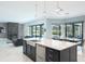 Modern kitchen island with sink and stainless steel dishwasher facing the outdoor dining area at 4012 Wellington Pkwy, Palm Harbor, FL 34685