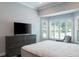 Comfortable main bedroom with a large bed, tv, and bay window with shutters at 4012 Wellington Pkwy, Palm Harbor, FL 34685
