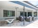 Covered outdoor patio with ceiling fans, modern furniture and travertine floors at 4012 Wellington Pkwy, Palm Harbor, FL 34685