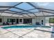 Outdoor screened-in pool area with pool, spa and travertine deck at 4012 Wellington Pkwy, Palm Harbor, FL 34685