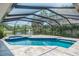 Sparkling pool and spa in screened lanai with serene lake view at 4012 Wellington Pkwy, Palm Harbor, FL 34685