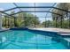 Screened-in pool with a lake view featuring a tiled deck and serene outdoor space at 4012 Wellington Pkwy, Palm Harbor, FL 34685