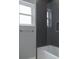 Modern shower featuring dark gray tiling with a built-in niche, a sleek towel bar and a glass enclosure at 4012 Wellington Pkwy, Palm Harbor, FL 34685