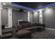 Home theater with projector, tiered seating, and a large sectional sofa for ultimate comfort at 4012 Wellington Pkwy, Palm Harbor, FL 34685