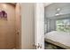 A bathroom featuring a glass shower with tiled walls, complete with toiletries and modern fixtures at 4324 S Clark Ave, Tampa, FL 33611