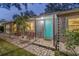 Inviting front entrance with a bright turquoise door, stone pathway, and manicured landscaping at 4324 S Clark Ave, Tampa, FL 33611