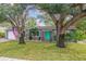 Charming home with a well-manicured lawn, mature shade trees, and a vibrant turquoise front door at 4324 S Clark Ave, Tampa, FL 33611