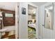 A hallway with doors leading to a bathroom with wood-look tile and a bedroom with colorful decor and a ceiling fan at 4324 S Clark Ave, Tampa, FL 33611
