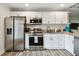 Bright kitchen with stainless steel appliances, white cabinets, and granite countertops at 4324 S Clark Ave, Tampa, FL 33611