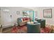 Cozy living room with a sofa, two chairs, a stylish rug, and a bright turquoise door at 4324 S Clark Ave, Tampa, FL 33611