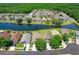 A serene aerial view of homes nestled around a lake with lush landscaping and mature trees at 4921 Wessex Way, Land O Lakes, FL 34639