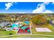 A scenic aerial view of a community park featuring a pool, playground, and sports areas surrounded by homes at 4921 Wessex Way, Land O Lakes, FL 34639