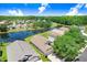 An aerial view of lush properties featuring homes along a lake and green spaces with mature trees at 4921 Wessex Way, Land O Lakes, FL 34639