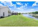 A spacious backyard features a beautiful lake view, screened-in patio, and lush green grass at 4921 Wessex Way, Land O Lakes, FL 34639