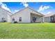 Backyard featuring a covered patio with seating overlooking lush green grass at 4921 Wessex Way, Land O Lakes, FL 34639