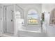 Bright bathroom featuring white bathtub, shower, and window at 4921 Wessex Way, Land O Lakes, FL 34639