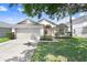 Well-maintained one-story home features a two-car garage and lush landscaping at 4921 Wessex Way, Land O Lakes, FL 34639