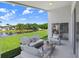 Covered patio with outdoor seating area overlooking a picturesque pond at 4921 Wessex Way, Land O Lakes, FL 34639