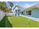 Backyard view of putting green, furniture, and exterior of home at 501 Janice Pl, Indian Rocks Beach, FL 33785