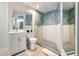 Modern bathroom features a glass shower with blue tile and white vanity at 501 Janice Pl, Indian Rocks Beach, FL 33785