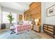 Charming bedroom featuring a wooden accent wall, a plush bed with a floral duvet, and ample natural light at 501 Janice Pl, Indian Rocks Beach, FL 33785