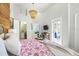 Bright bedroom with a vaulted ceiling, a stylish chandelier, and a partial view into the living area at 501 Janice Pl, Indian Rocks Beach, FL 33785