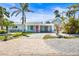 Charming blue exterior with lush tropical landscaping and a welcoming pink front door at 501 Janice Pl, Indian Rocks Beach, FL 33785